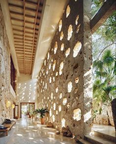 the interior of a house with stone walls and floor to ceiling windows on each side