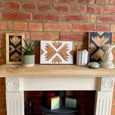 a fireplace with some pictures on top of it and a potted plant next to it