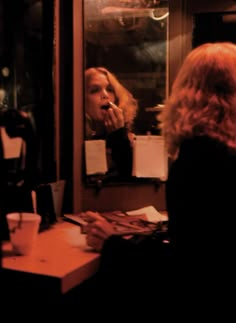 a woman brushing her teeth in front of a mirror