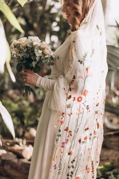 a woman in a white dress holding flowers