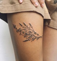 a woman's thigh with flowers and leaves tattoo on her leg, next to the words tattoospiraton