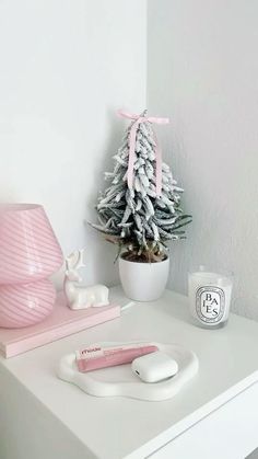 a white desk with a pink christmas tree and other items on it, including an electric toothbrush