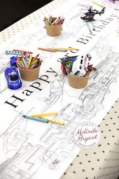 there are pencils and crayons in small pots on the table with writing