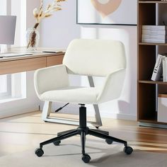 a white office chair sitting on top of a wooden desk next to a book shelf