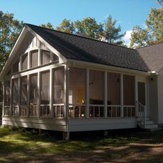 a white house sitting in the middle of a forest