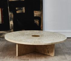 a table with a circular design on it in front of a black and white painting