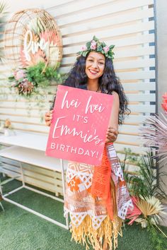 a woman holding a sign that says he hoi it's emmetts birthday