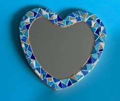 a heart shaped mirror on a blue background