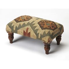 a foot stool made out of an old rug with wooden legs and feet, on a white background