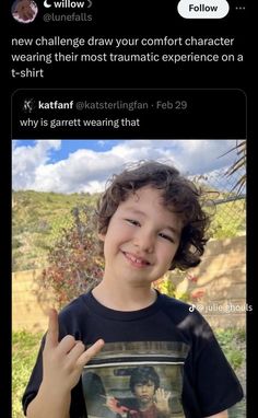 a young boy is smiling and pointing at the camera with an instagramtion on his t - shirt