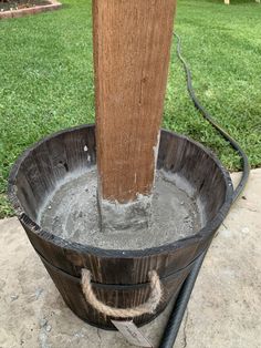 a bucket filled with water next to a wooden pole