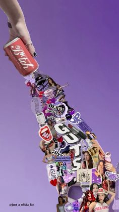 a hand reaching for a can of soda on top of a collage of stickers