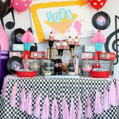 a table topped with lots of pink and black items on top of a checkered table cloth