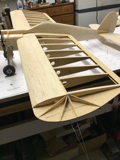 an airplane made out of wood sitting on top of a table