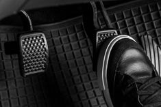 black and white photograph of someone's shoes in the back seat of a car