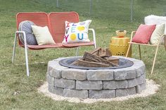 a fire pit in the middle of some lawn chairs with pillows on them and one chair next to it