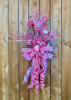 a red, white and blue wreath with candy canes hanging on a wooden fence