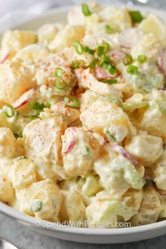 a white bowl filled with potato salad on top of a table