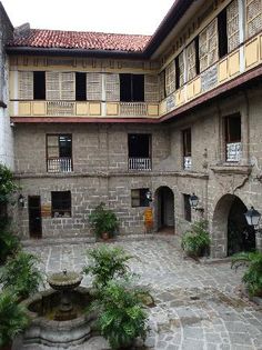 the courtyard of an old building with potted plants