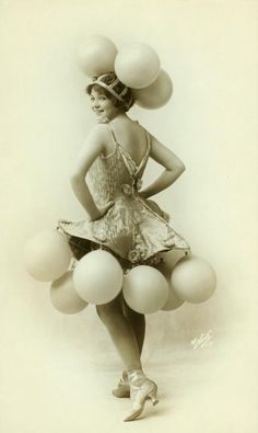 an old photo of a woman in a dress with balloons on her head and legs