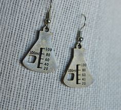 These earrings are a super cute way to show off your love of science. It is made from a zinc alloy metal which is lead and nickel free. They are antique bronze colored.  They measure 1 inch long. The earring posts are antique tone costume jewelry.  Stainless steel posts are available upon special request.   If you would like to order multiples of this listing, message me for details.  Thank you for shopping with me! Follow me on Instagram for coupon codes, new inventory, and sales! @biolojewelry   I ship USPS so, please allow 3-10 business days for your item to arrive after you receive your shipping notification. (USA) Please allow 10-40 business days for international delivery. Chemical Earrings, Chemistry Earrings, Biology Earrings, Science Beaker, Chemistry Necklace, Chemistry Jewelry, Science Themes, Science Biology, Earring Posts