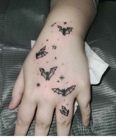 a hand with some bats on it and stars in the sky above it, as well as an ink tattoo design