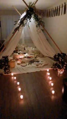 a table set up with candles and food for a party or gathering in the middle of a room