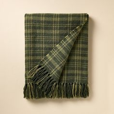 a green and black plaid blanket hanging on a wall