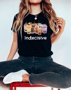 a woman sitting on top of a stool wearing an indecisive t - shirt