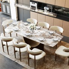 a dining room table set with white chairs