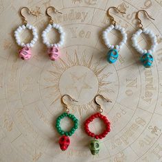 six pairs of colorful beaded skull earrings on a circular table with an astro sign in the background