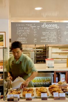 a man working behind the counter at a bakery