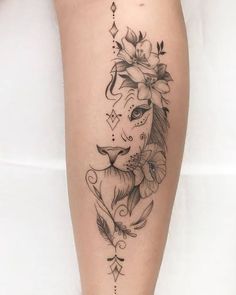 a woman's leg with flowers and a lion tattoo on the side of her thigh