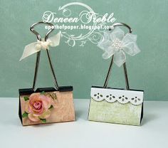 two small purses with bows on them are sitting next to each other, one is decorated with lace and the other has a flower