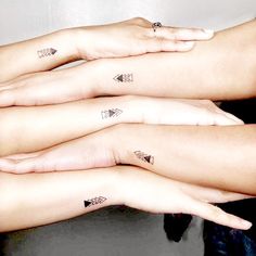 three women with matching tattoos on their arms are holding onto each other's hands