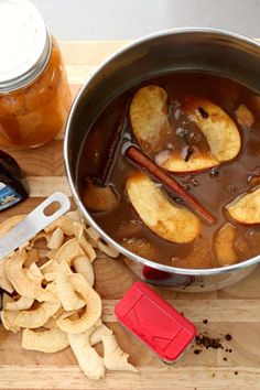 a pot filled with food next to a knife and some chips on a cutting board