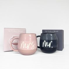 three coffee mugs sitting next to each other in front of a card and box