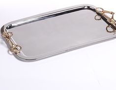 a silver tray with gold handles on a white surface