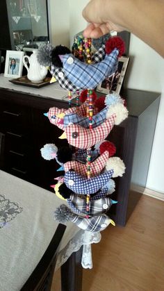 a hand is holding a stuffed animal in front of a table with other items on it