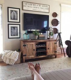 a person laying on the floor in front of a tv with their feet propped up