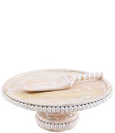 a white cake plate with pearls on the edge and a wooden serving platter in the middle