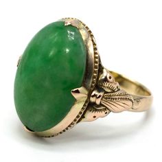 This lovely ring—probably made in the 1920s—is made of gold fill and is replete with elegantly simple Arts & Crafts design elements. The central stone is an oval piece of verdant nephrite jade. Metal: Gold Fill Main Stone: 1 Oval Cut Cabochon Jade (nephrite, 16.11 x 11.36 mm) Ring Size: 6.0 (can be sized) Antique Emerald Ring Oval Cabochon, Antique Emerald Ring With Oval Cabochon, Green Domed Jewelry With Polished Finish, Antique Oval Cabochon Emerald Ring, Antique Green Emerald Ring With Polished Finish, Vintage Emerald Oval Cabochon Ring With Polished Finish, Vintage Polished Emerald Ring With Oval Cabochon, Vintage Oval Cabochon Emerald Ring With Polished Finish, Heirloom Green Oval Cabochon Jewelry