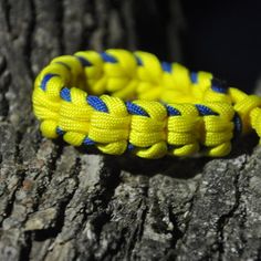 a yellow and blue bracelet sitting on top of a tree