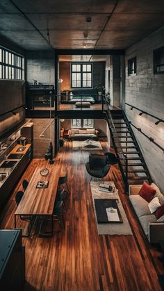 a living room filled with furniture next to a wooden floor and staircase leading up to a loft