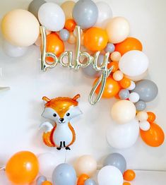 a baby shower with balloons and an orange fox balloon in the shape of a fox