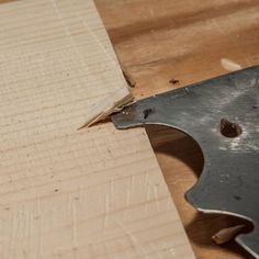 a piece of wood that has been cut in half with a large metal blade on it