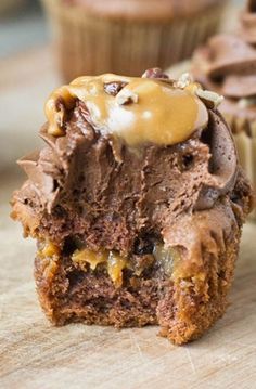 a chocolate cupcake with caramel drizzled on top and half eaten