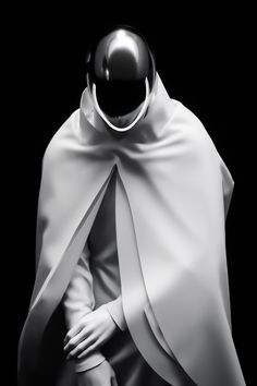 a black and white photo of a person wearing a cape with a helmet on it