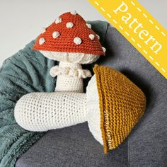 a crocheted mushroom sitting on top of a gray couch next to a pillow