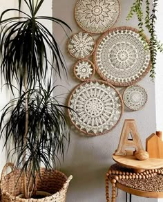 some plants are hanging on the wall next to two wicker baskets and a table